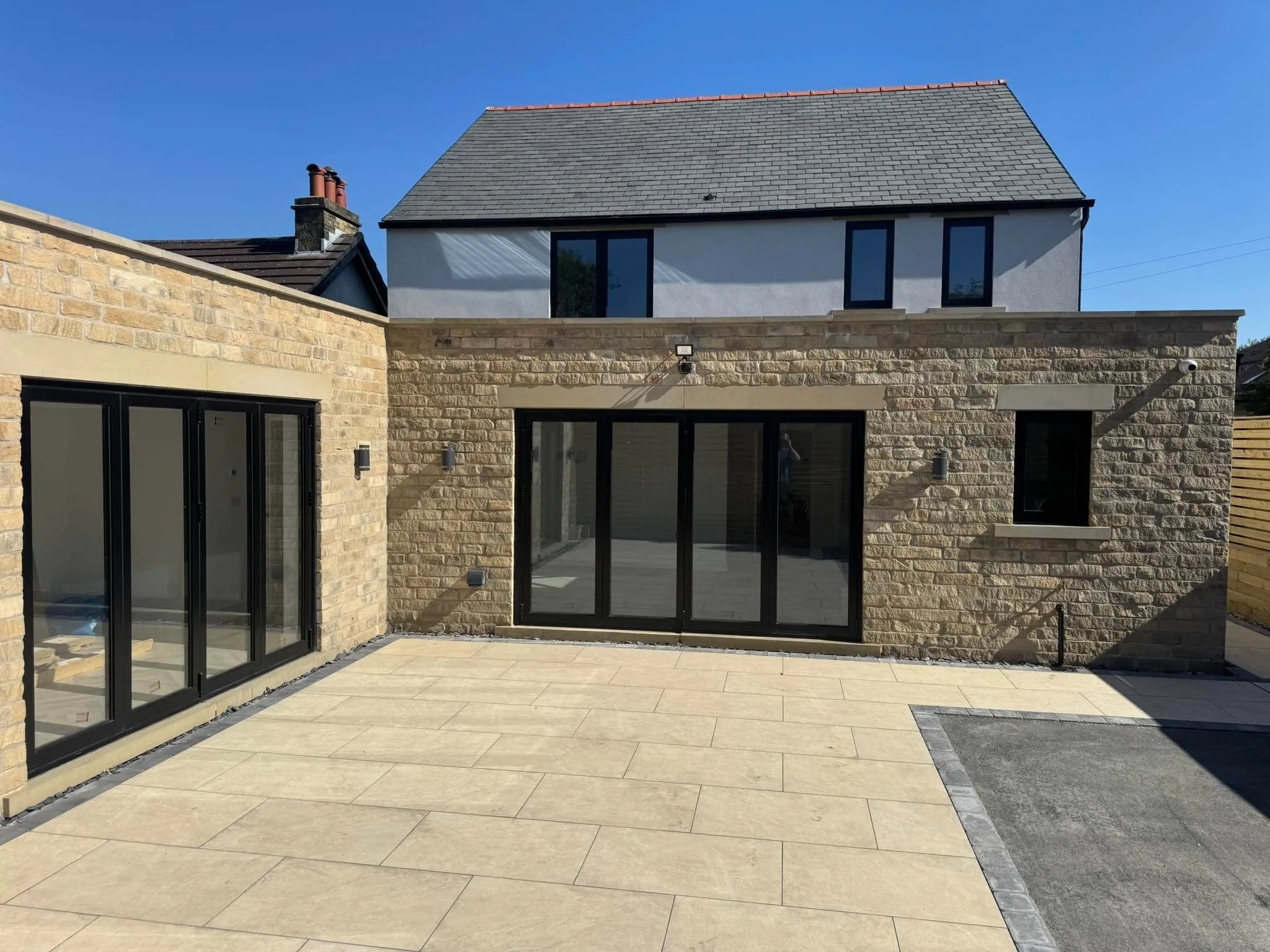 A house with a large patio and a stone wall.