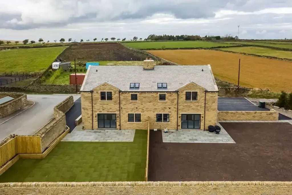 an aerial view of a house in the middle of a field