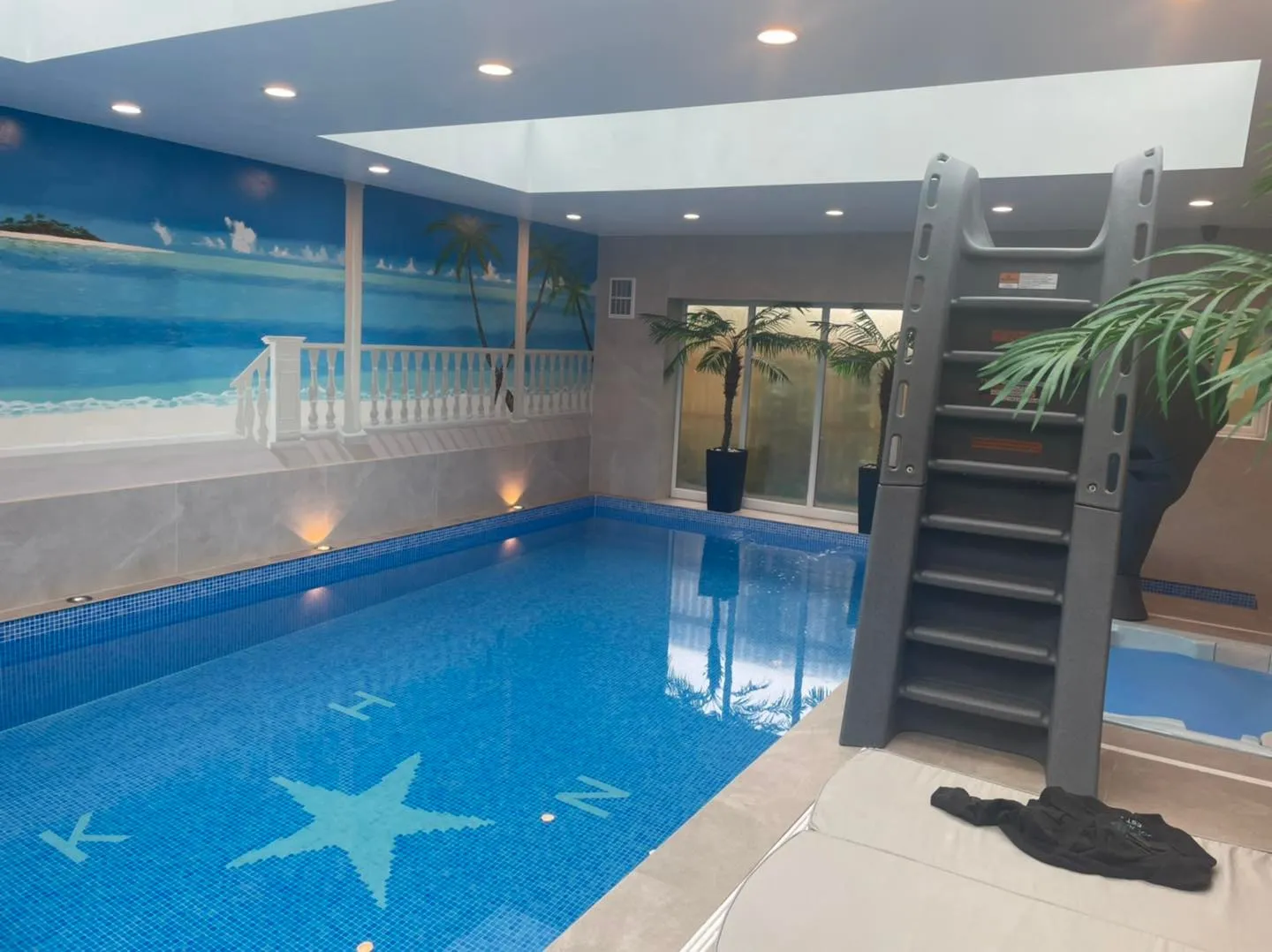 A large indoor swimming pool with stairs leading up to it.